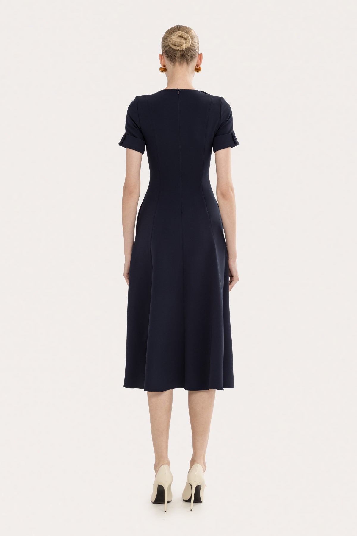 Back view of a navy structured A-line midi dress with short sleeves and a clean tailored shape