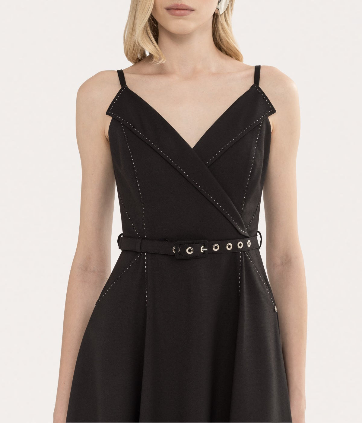 Close-up of black sleeveless midi dress with deep V neckline, lapel detail, and contrast topstitching