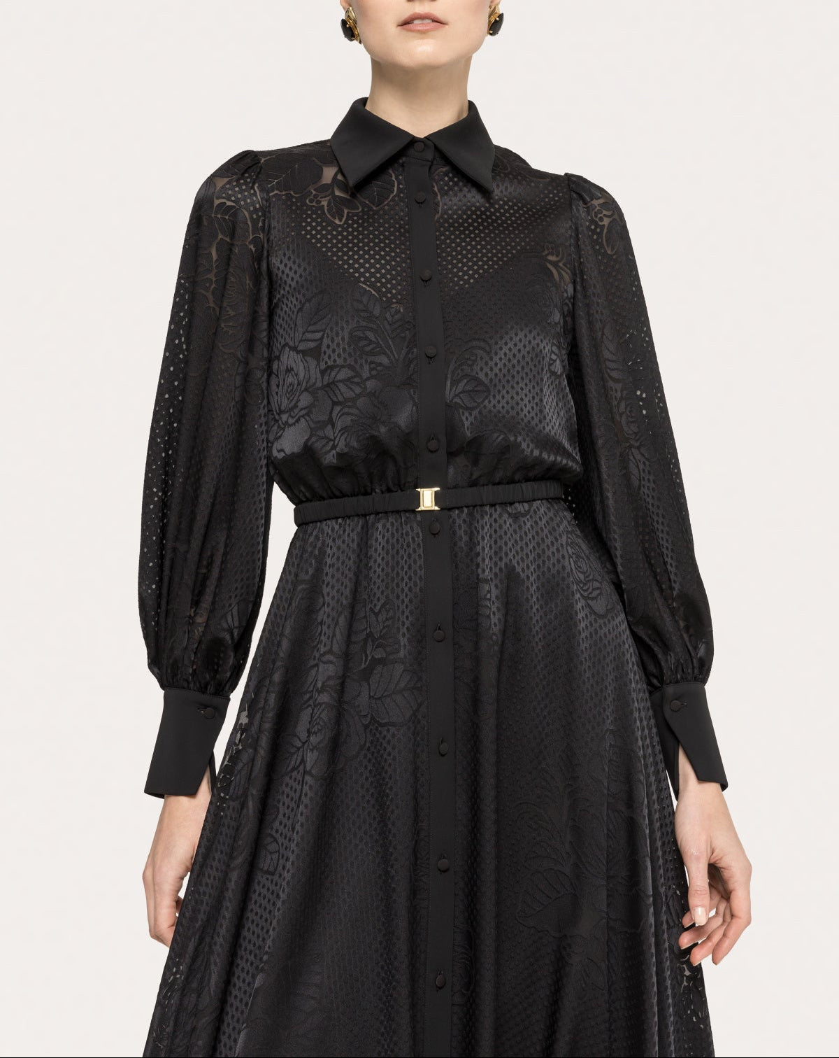 Close-up of a black tonal floral midi cocktail dress with pointed collar, covered placket, and waist belt
