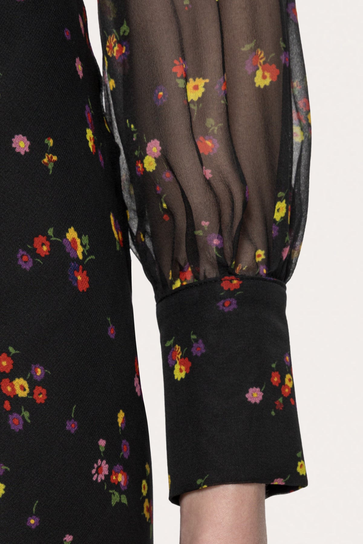 Close-up of the sheer floral long sleeve gathered into a wide buttoned cuff