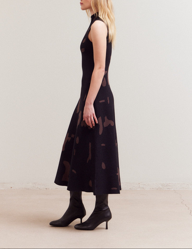 Woman wearing a black sleeveless dress with pattern