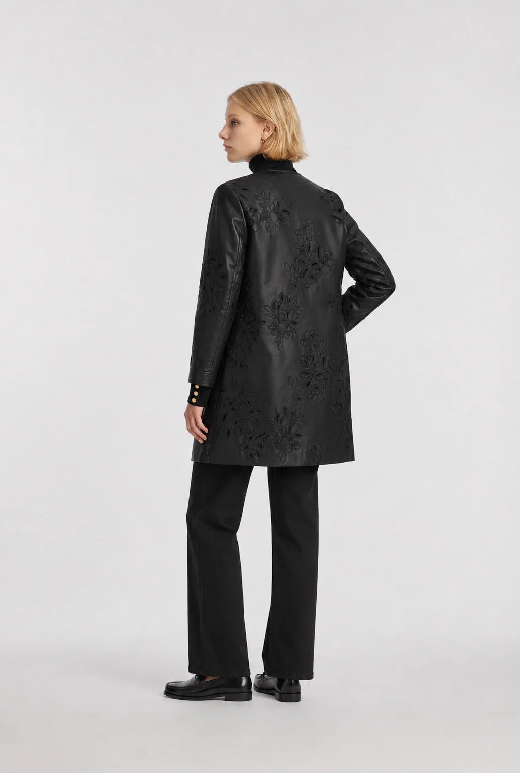 Back view of a Weill Paris black faux leather coat with floral embroidery across the back and sleeves.