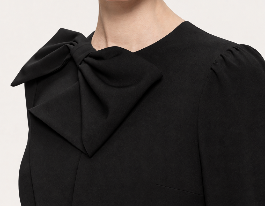 Close-up of the oversized black bow at the crew neckline of NISSA’s structured midi dress.