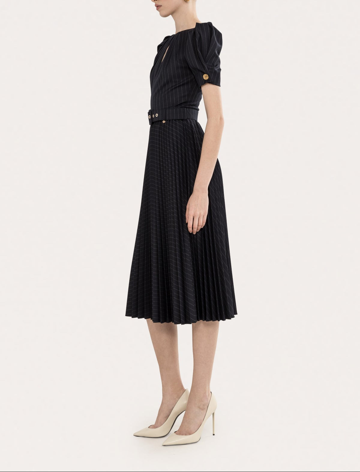 Side view of a black pinstripe puff sleeve pleated midi dress with belt and softly pleated skirt
