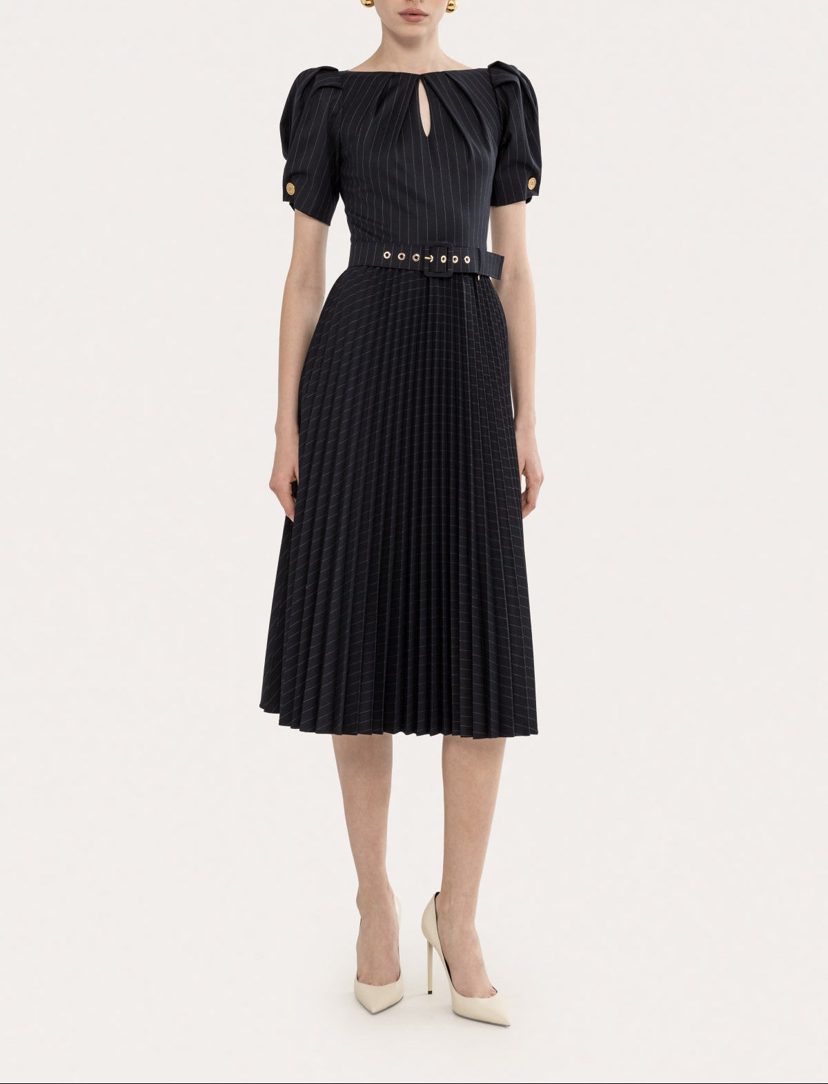 Front angled view of a black pinstripe puff sleeve pleated midi dress with belt, keyhole neckline, and pleated skirt