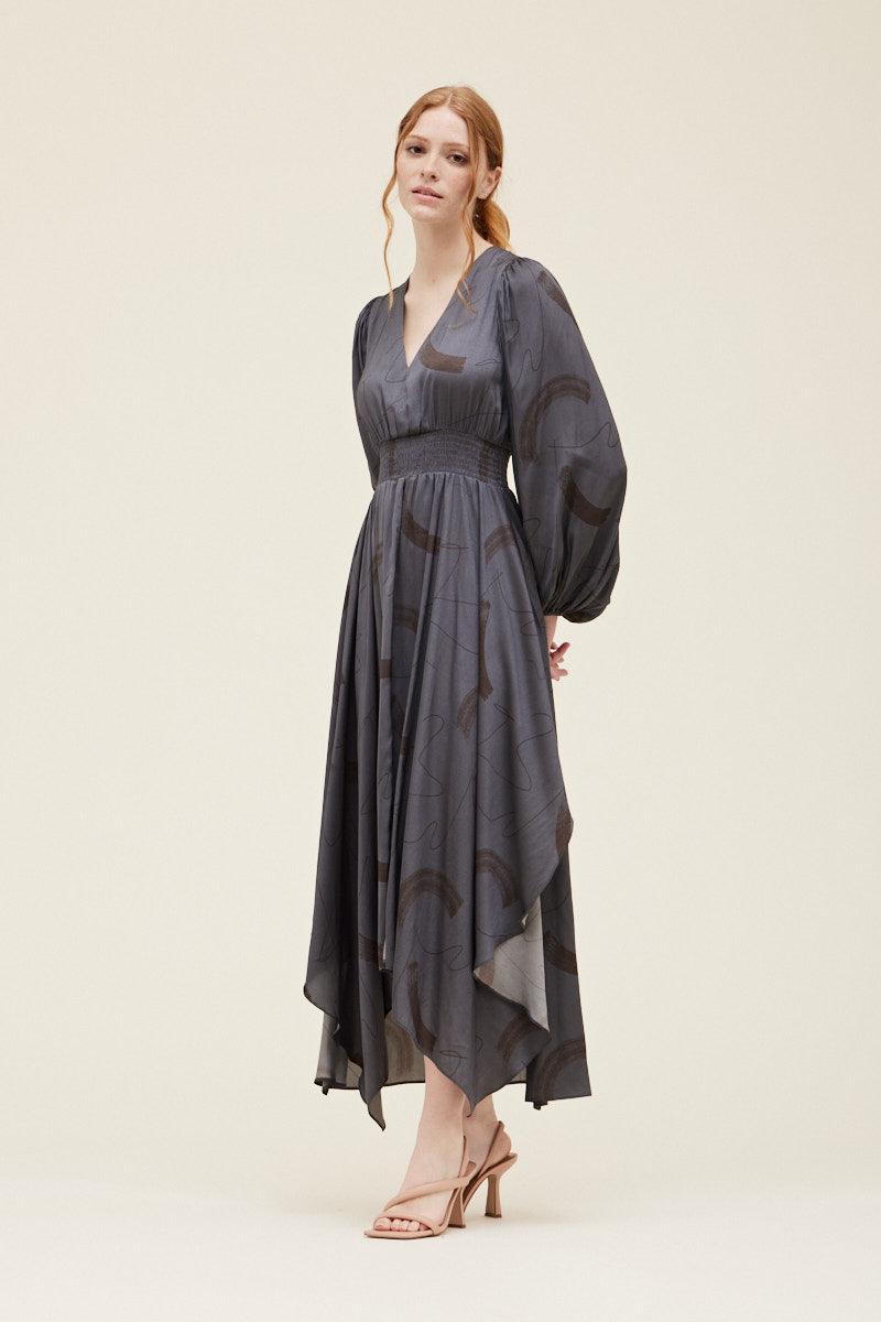 Three-quarter view of the Grade & Gather Slate satin maxi dress showing the pointed asymmetrical hem.