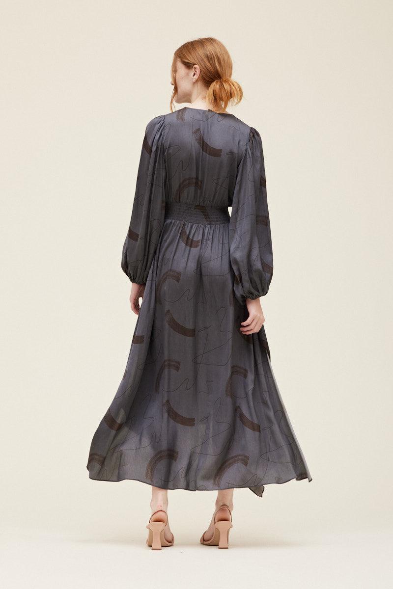 Back view of the Grade & Gather Slate satin maxi dress showing the covered back, smocked waist and flowing skirt.