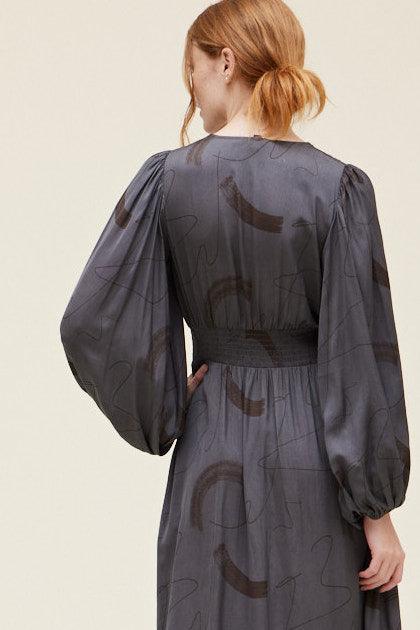 Back detail of the Grade & Gather Slate dress showing the dark abstract print, smocked waist and gathered cuffs.