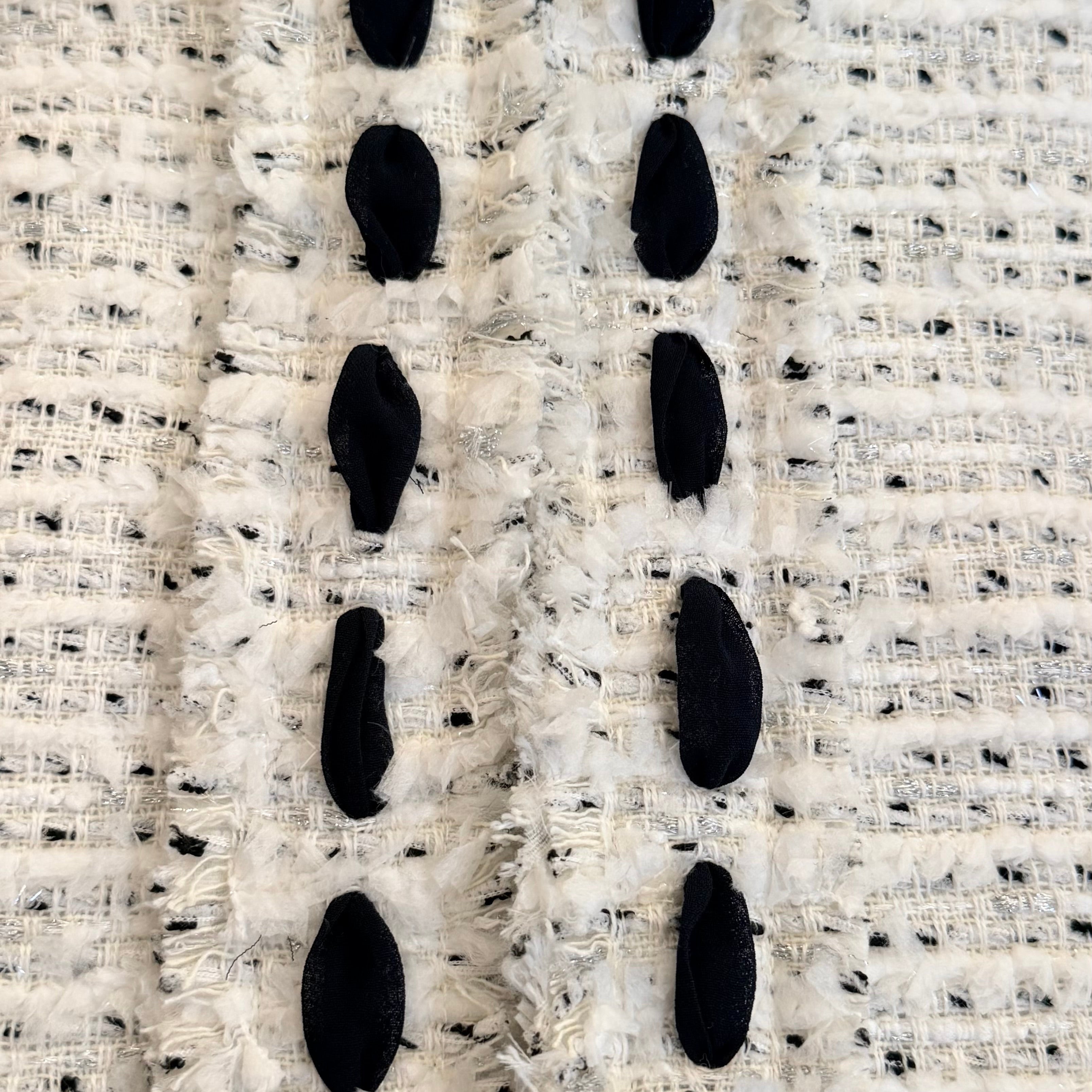 Close-up of the Weill Paris ivory bouclé tweed jacket showing black contrast trim and frayed front placket detail