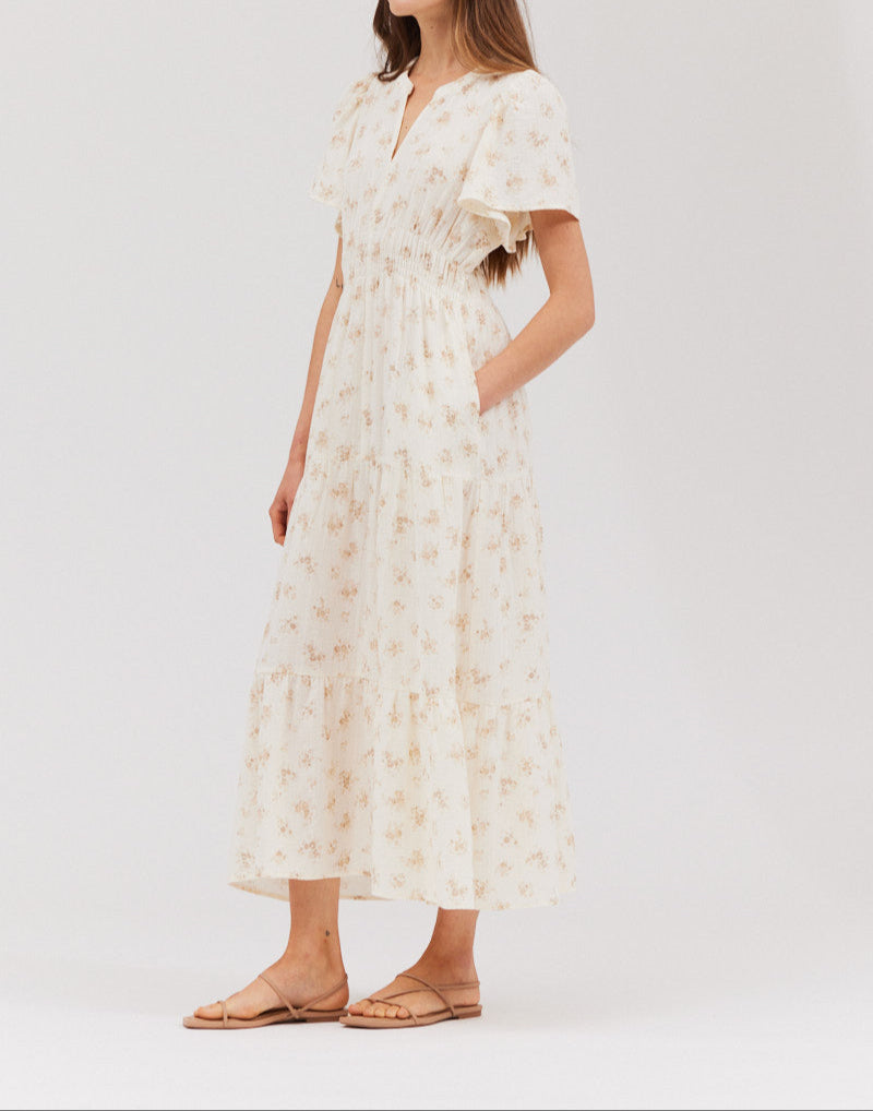 3/4 view showing the notched V‑neck, flutter sleeve, and smocked waist of the printed gauze midi dress in natural floral.