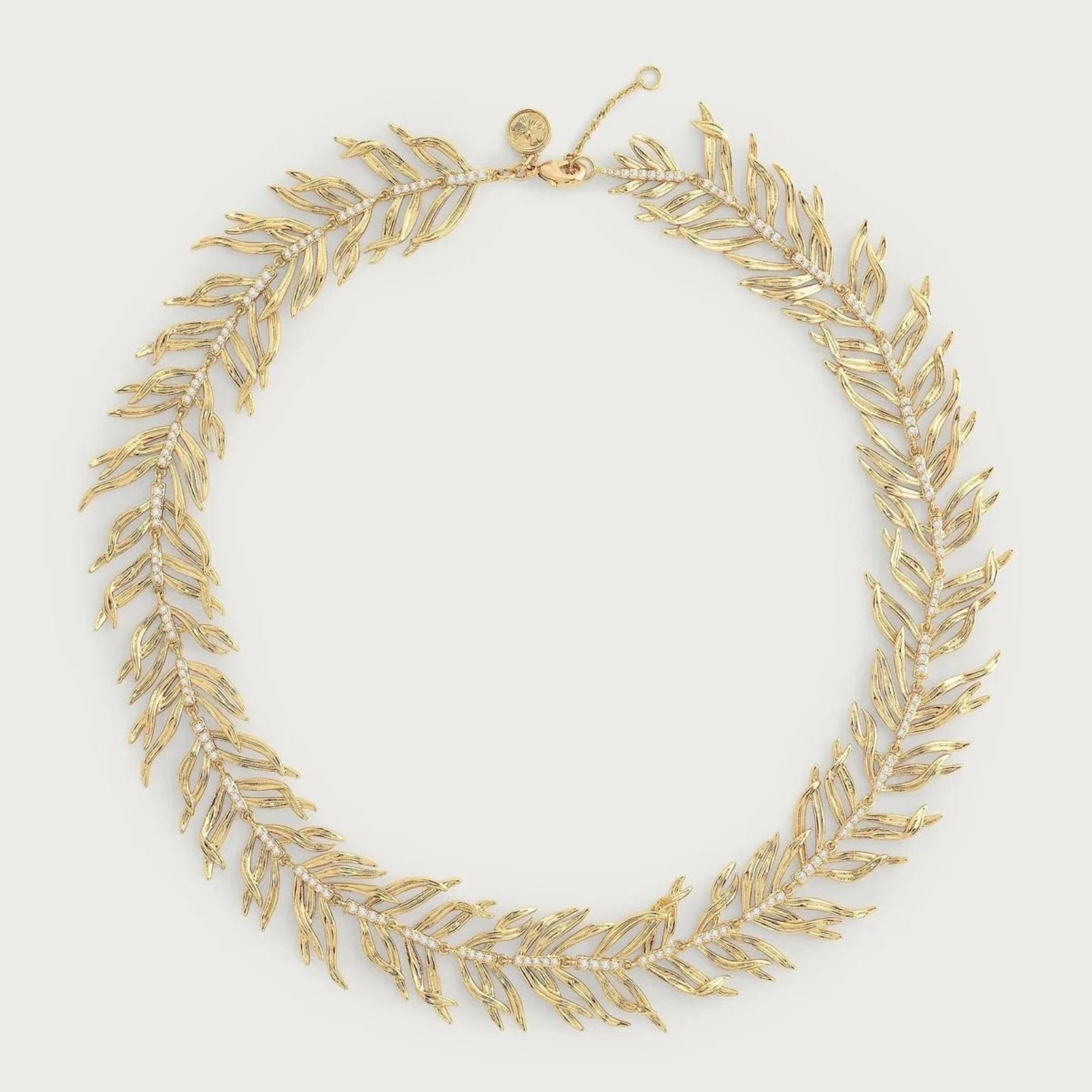 Anabel Aram Palm Leaves Necklace featuring sculpted palm‑leaf links in gold‑plated brass with hand‑set crystals and an adjustable 15–16‑inch chain.