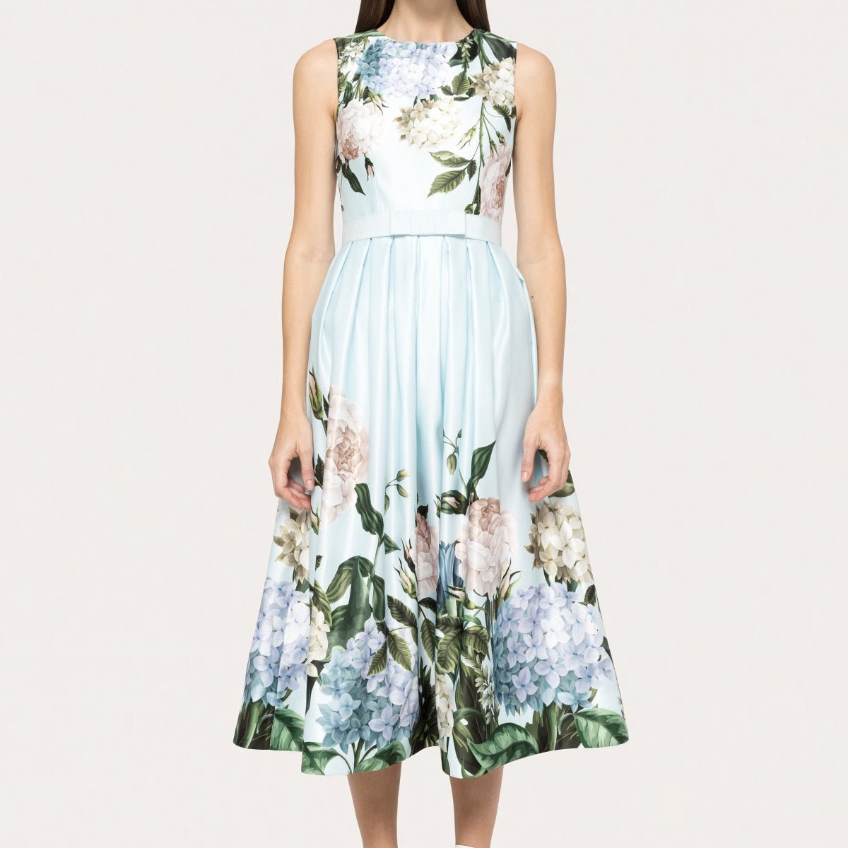 Model wearing a sleeveless light blue taffeta midi dress with oversized floral print by NISSA - BTK COLLECTIONS