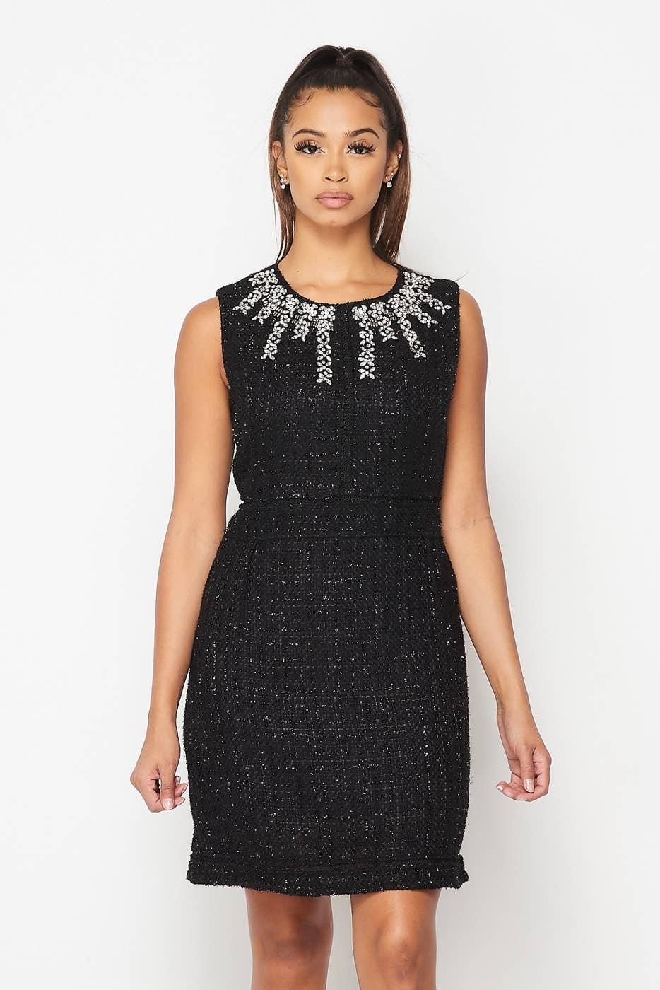 Front view of the black embellished mini dress, showing cascading neckline jewels, sleeveless shoulders and tonal waist and hem trim.