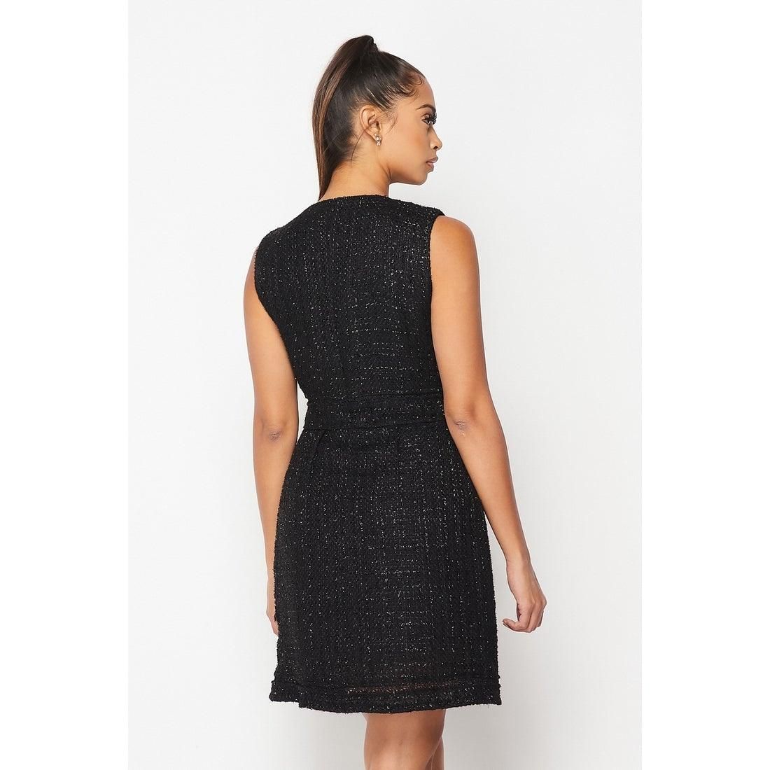 Back view of the Like the Moon black sleeveless dress, showing its covered back, textured fabric, defined waist and short hem.