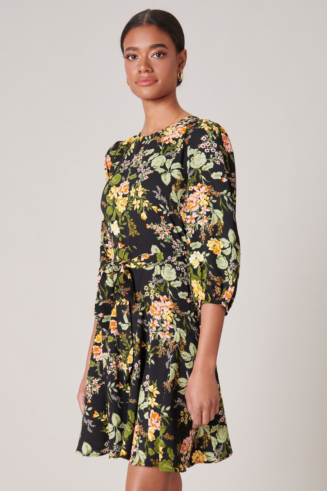 Side view of black floral fit-and-flare mini dress with 3/4 sleeves