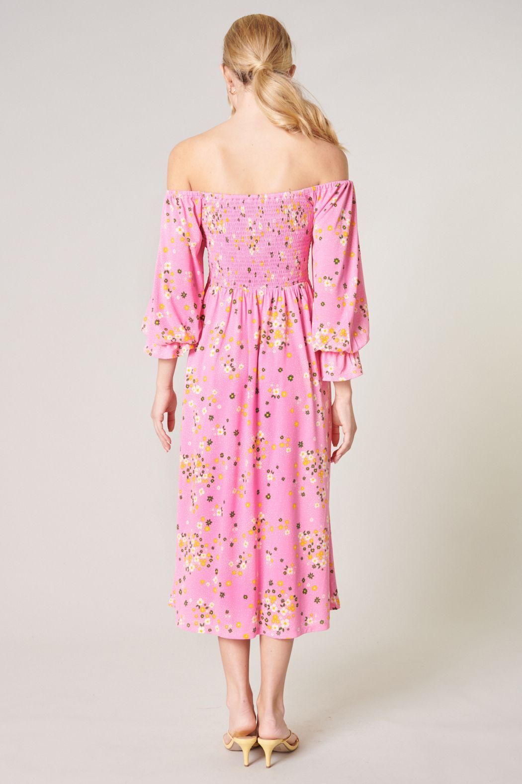 Back view of Sugarlips Spring Dream pink floral off-shoulder midi dress showing the smocked back and flowing skirt