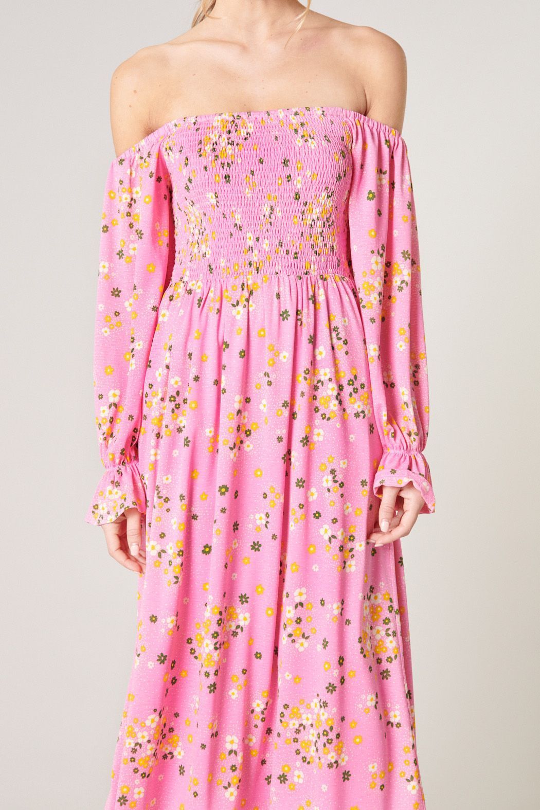 Close-up of Sugarlips Spring Dream dress showing pink floral print, smocked bodice and ruffled sleeve cuffs