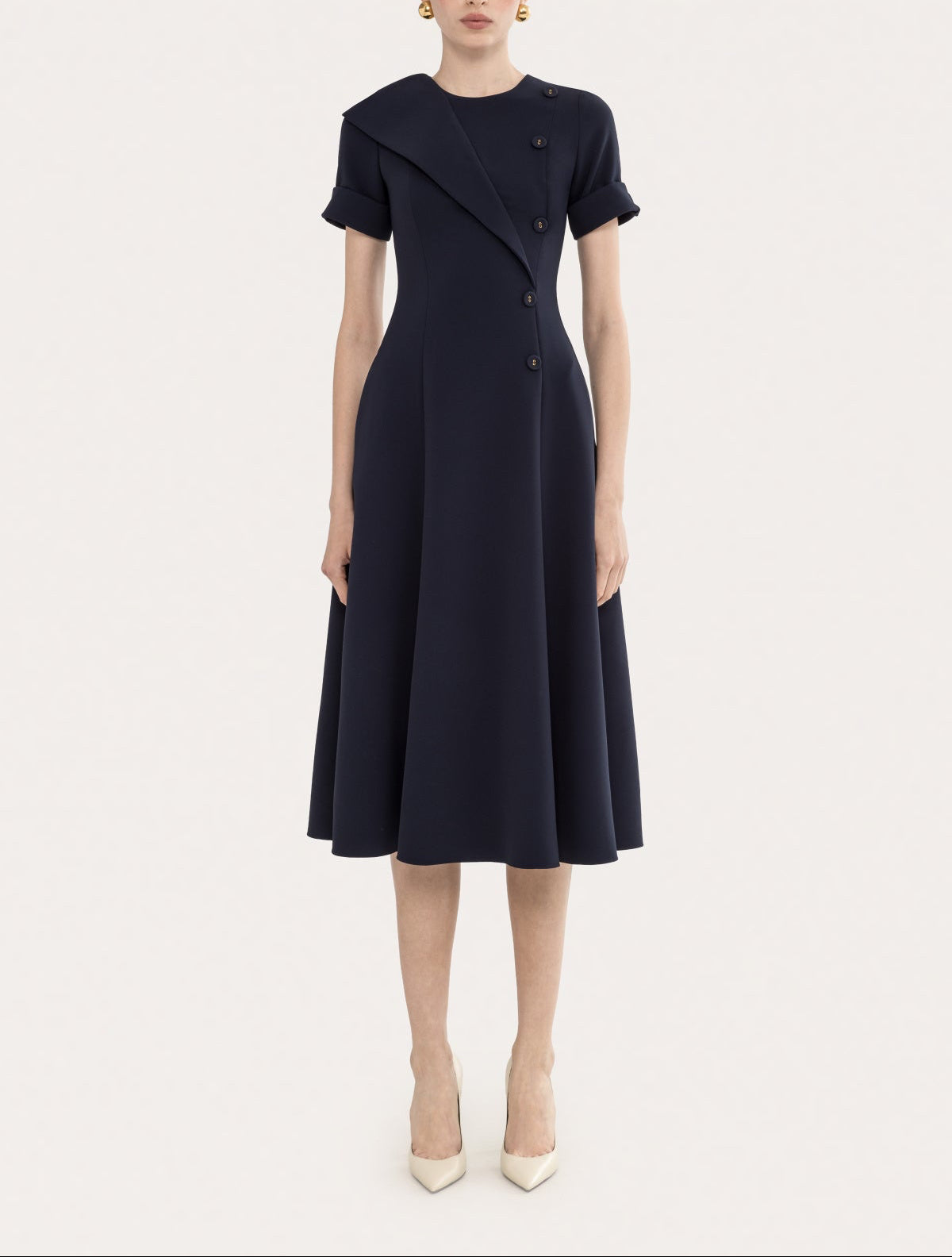 Front view of a navy short sleeve A-line midi dress with button detail and a polished tailored silhouette