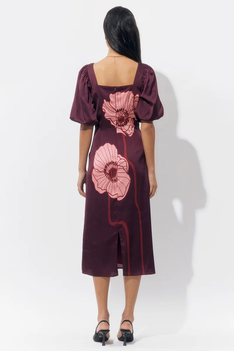 Back view of the Alena Puff Sleeve Poppy Maxi Dress showcasing the concealed zipper, back slit, and continuous floral print from top to hem.