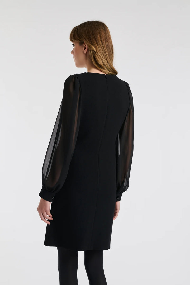 Back three‑quarter: Weill black dress with sheer sleeves, wool crêpe cuffs and concealed back zip.