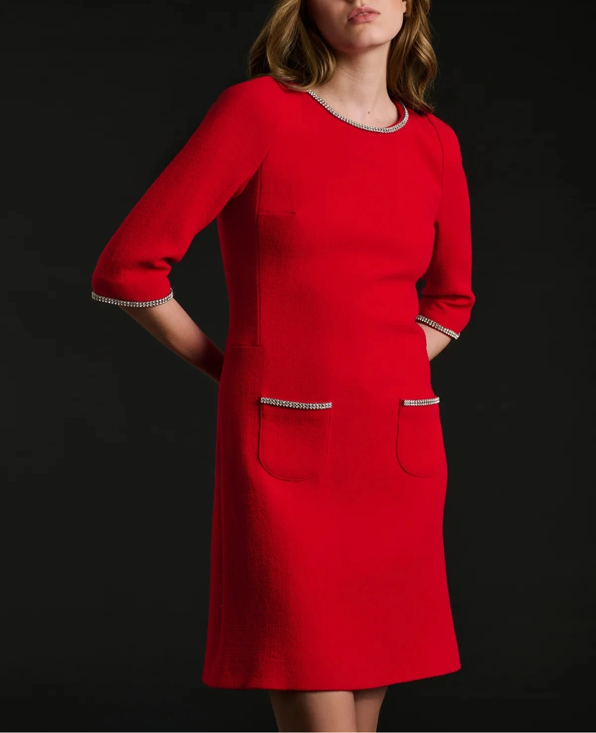 Close‑up of jewel neckline with rhinestone trim on red wool‑crêpe shift dress.