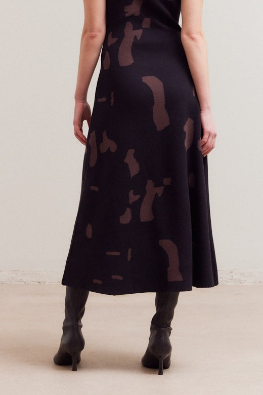 Close-up of the knit fabric featuring a black and brown abstract pattern, highlighting the texture and pattern details.