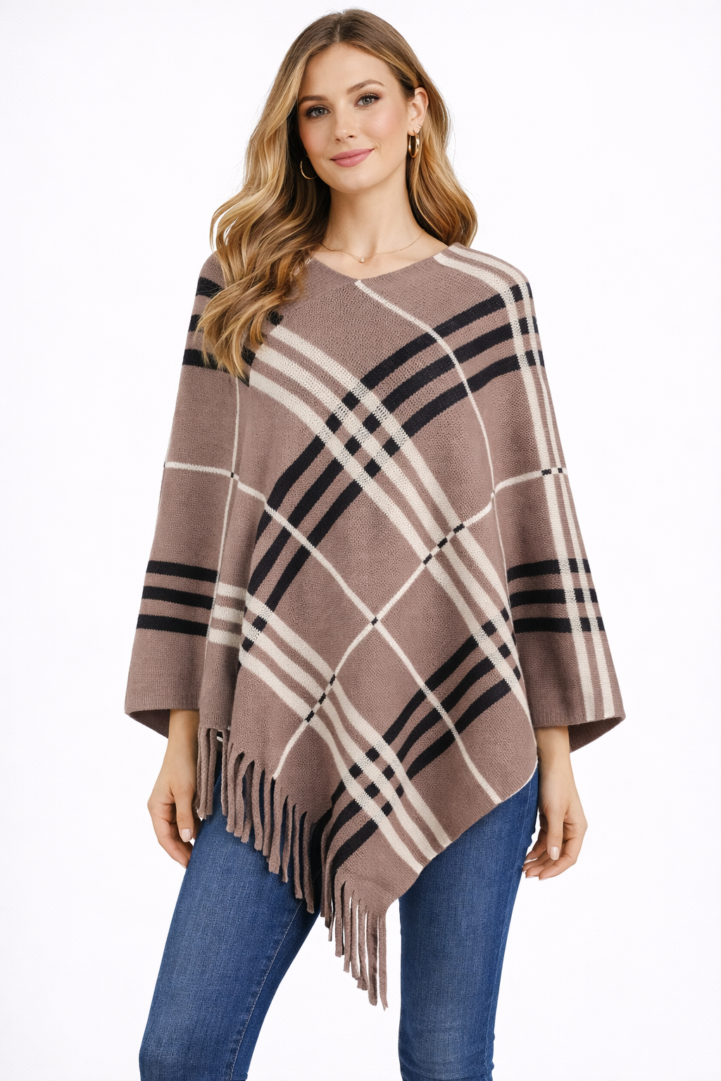 Woman wearing a plaid poncho with fringe details on a white background