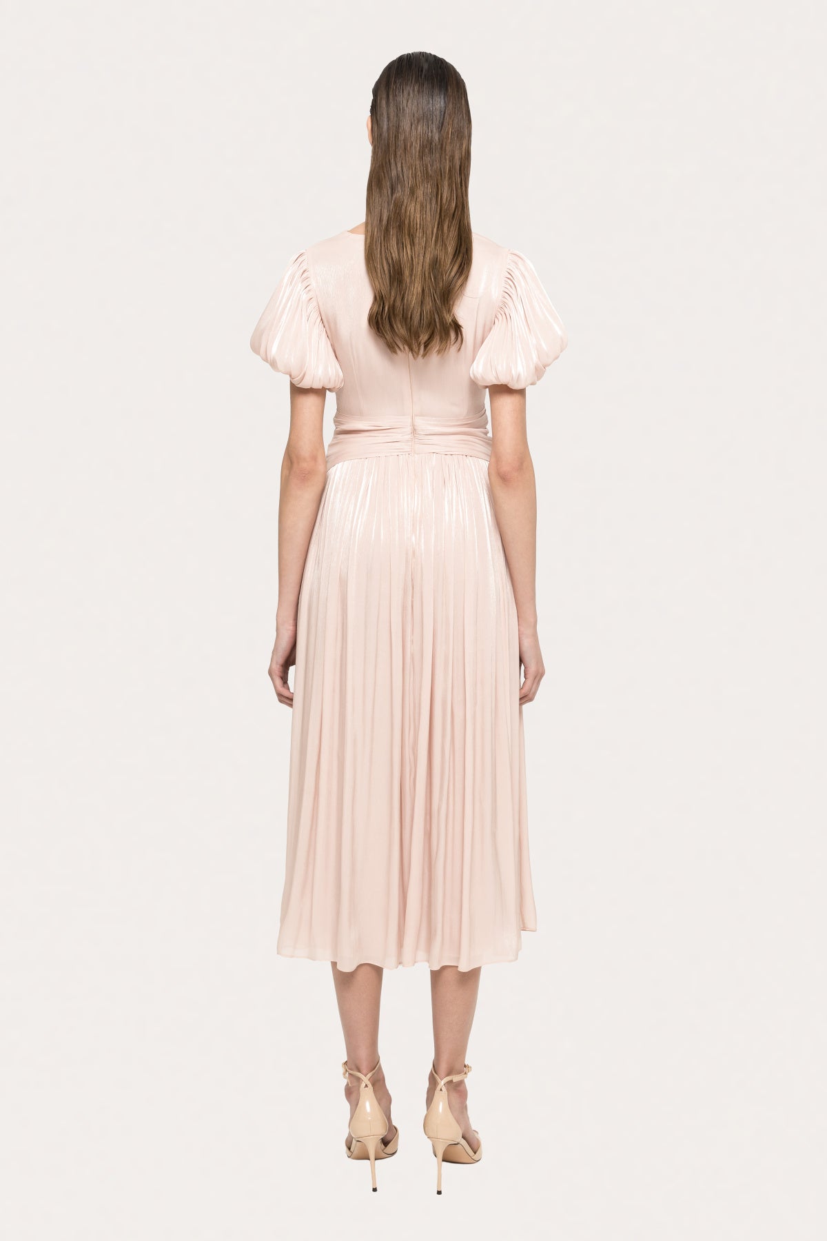Back view of blush metallic midi dress with pleated skirt and short puff sleeves