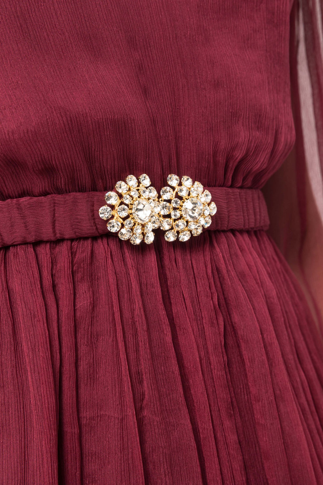 Wine midi with V‑neck, airy sleeves, 3D flower at shoulder and pleated skirt.