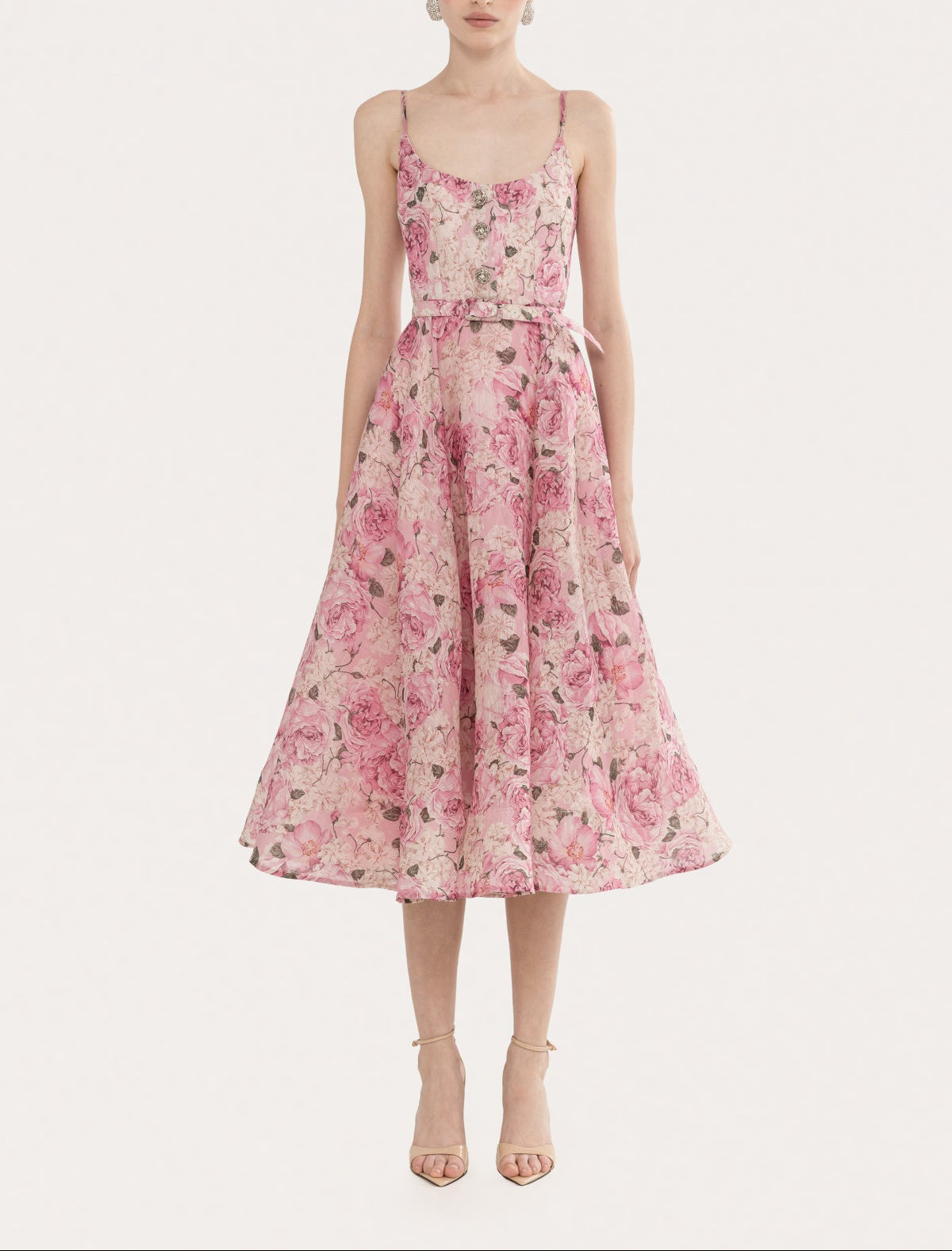 Front view of a pink floral linen-silk fit-and-flare midi dress with scoop neckline, adjustable spaghetti straps, floral button detail, and self belt