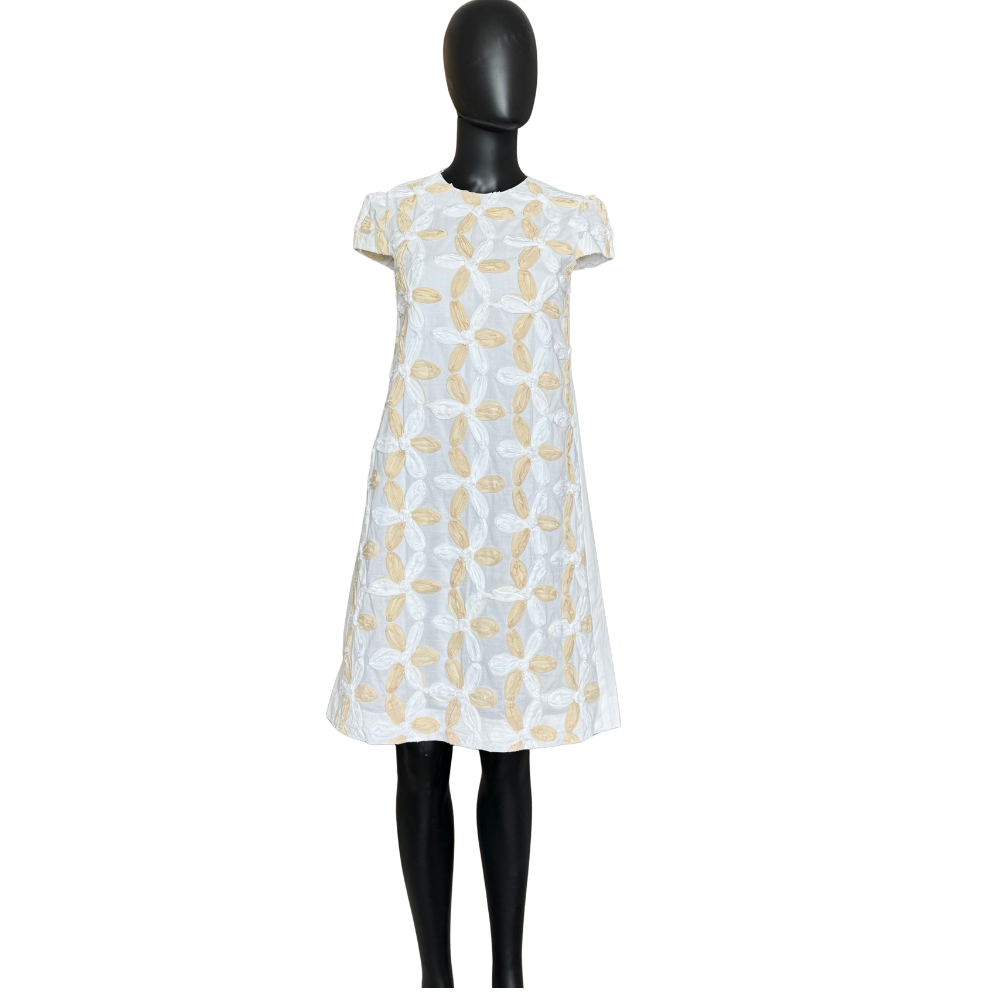 White dress with yellow pattern on a mannequin against a white background