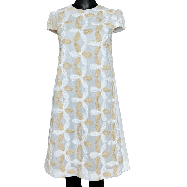 White dress with beige floral pattern on a white background