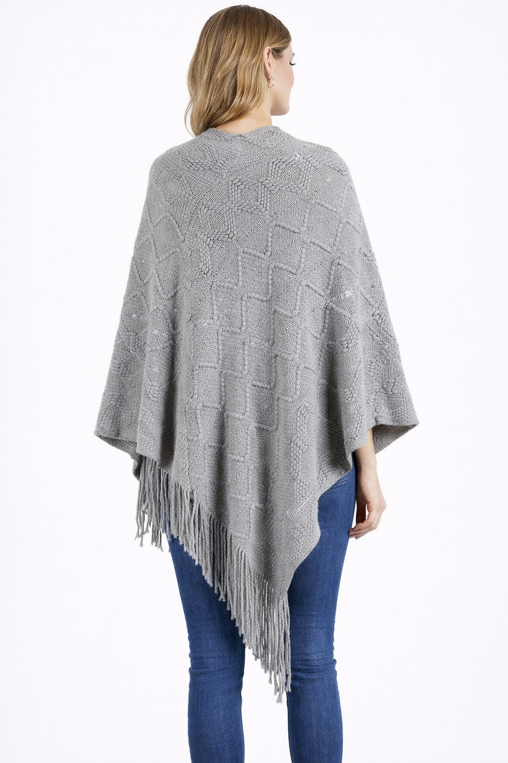 Woman wearing a gray poncho with fringe details on a white background
