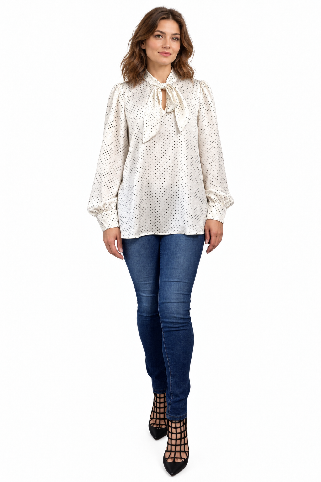 Full outfit showing an ivory pin-dot bow-neck blouse worn untucked with dark jeans and black heels.