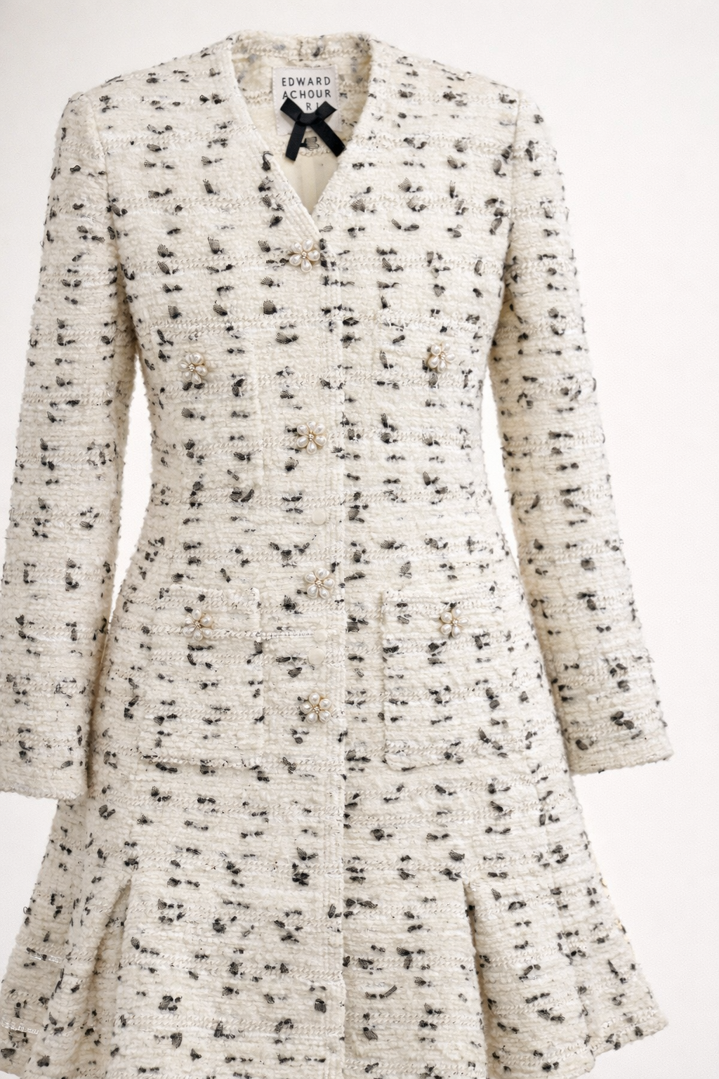 White dress with black pattern and black bow tie on a white background