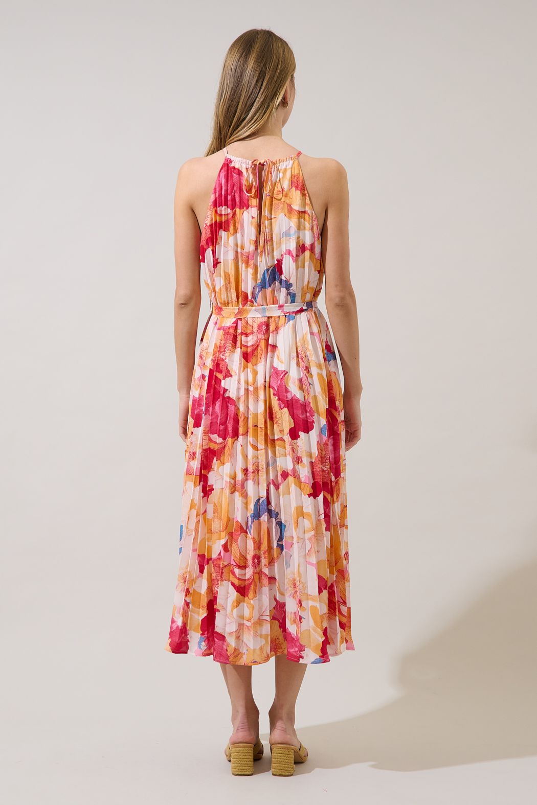 Back view of Maly coral floral pleated midi dress with a self-tie halter neck and low-cut keyhole opening