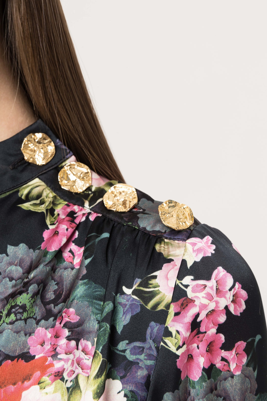 Close-up of gold buttons on shoulder with floral print