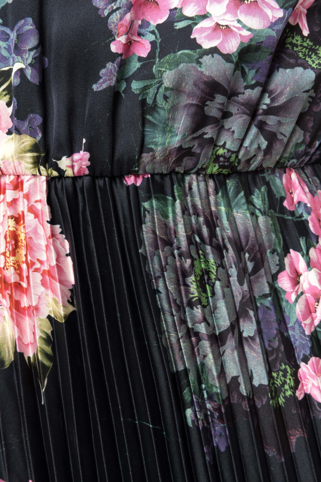 Close‑up of painterly peony floral print and fine knife pleats on black fabric