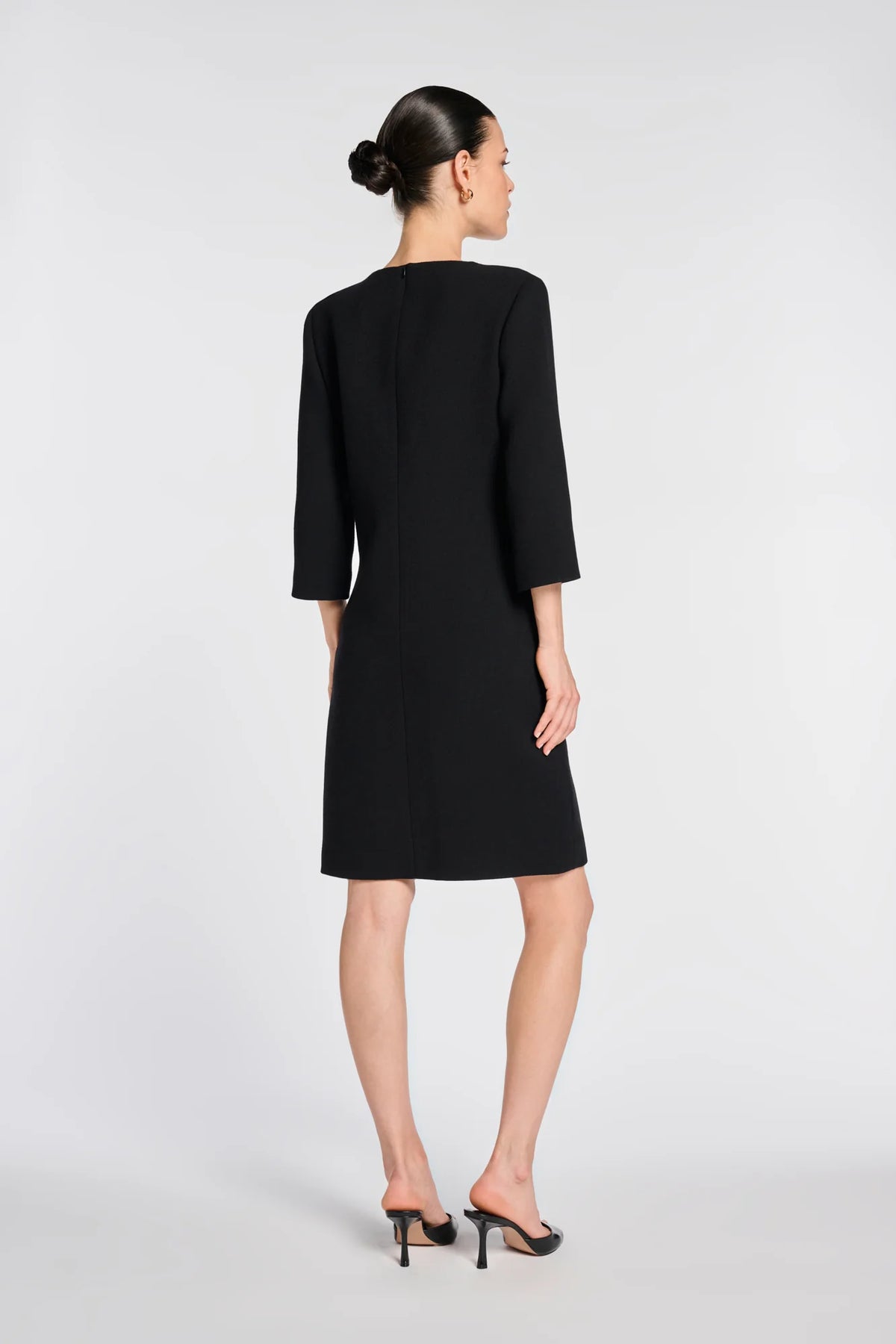 Full-length back view of Weill black shift dress with a straight hem, above-knee length and three-quarter sleeves.