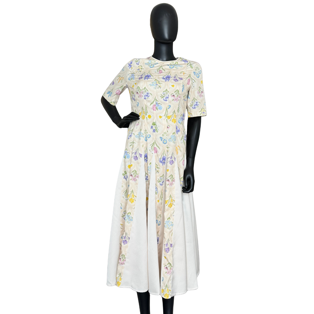 Yellow mosaic floral midi dress by Nora Noh in soft cream with multicolor floral print, elbow sleeves, crew neckline, and paneled fit-and-flare skirt.
