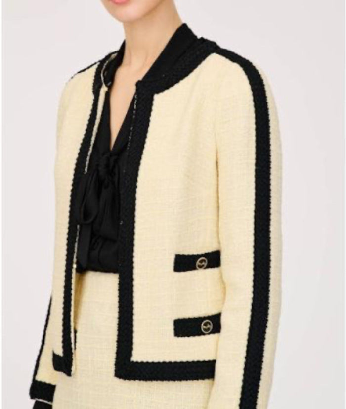 Three-quarter view of WEILL Paris ecru tweed jacket showing black sleeve trim and gold-tone pocket buttons.