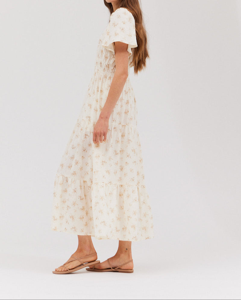 Left side profile of the sweater‑layer‑friendly floral gauze midi dress highlighting the airy tiers and flutter sleeve.