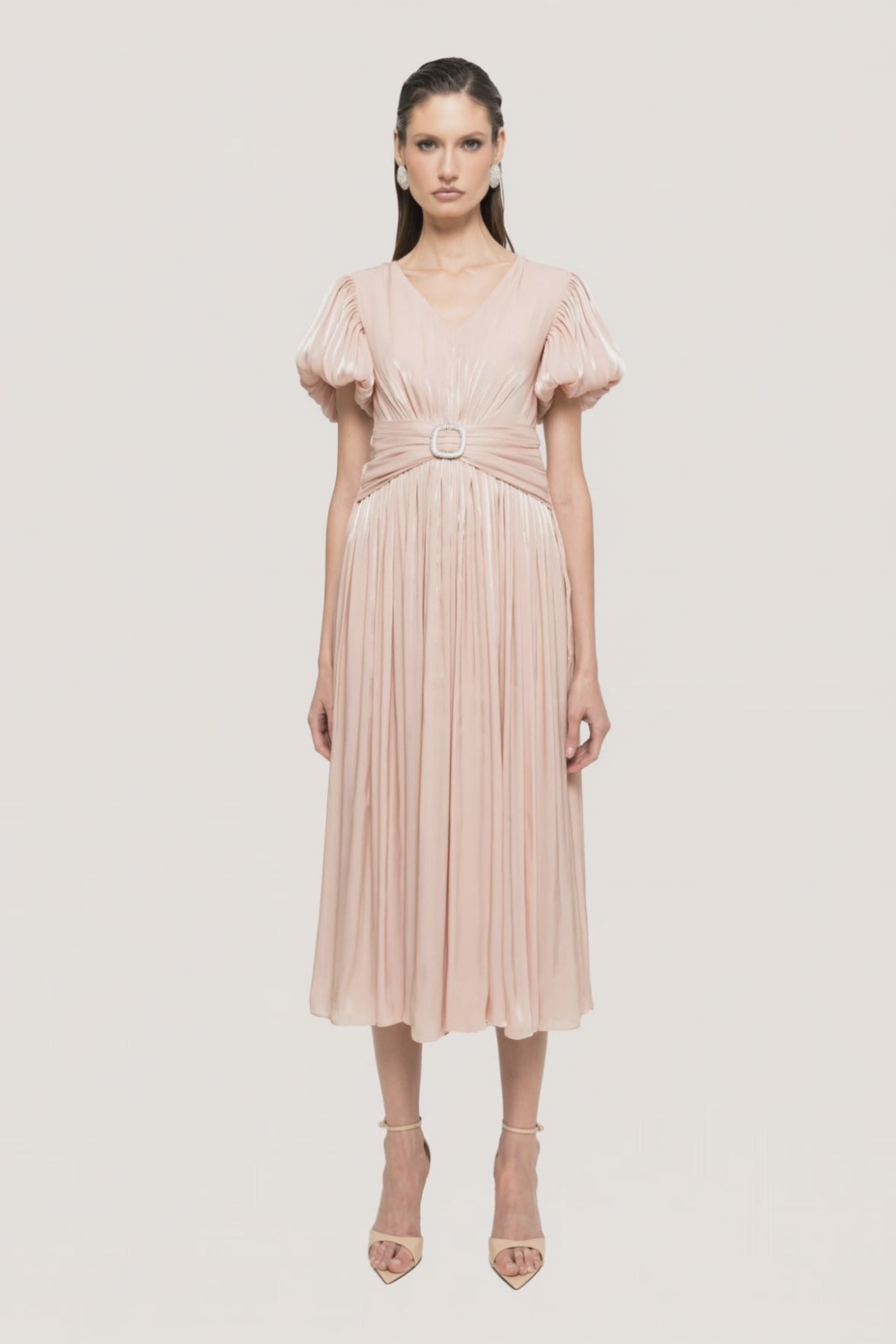 Blush metallic pleated midi dress with puff sleeves, deep V-neckline, fitted waist, and crystal buckle detail
