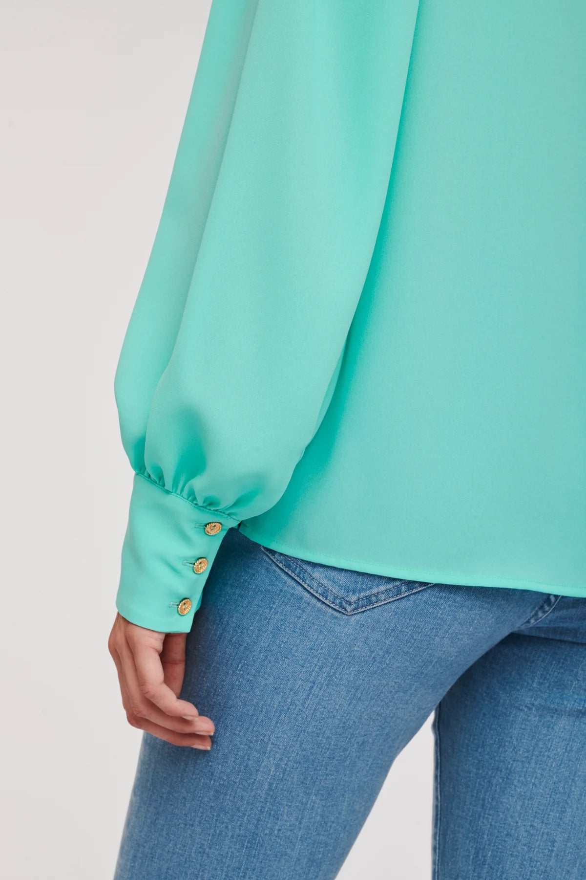 Close-up of turquoise WEILL blouse cuff with three gold-tone buttons and gathered sleeve