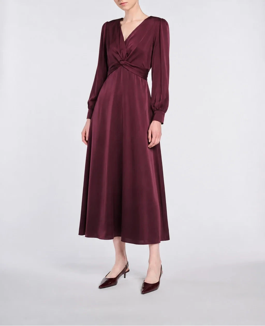 WEILL Paris burgundy satin midi dress with a wrap-effect V-neck, crossover draped waist and long sleeves, front view.