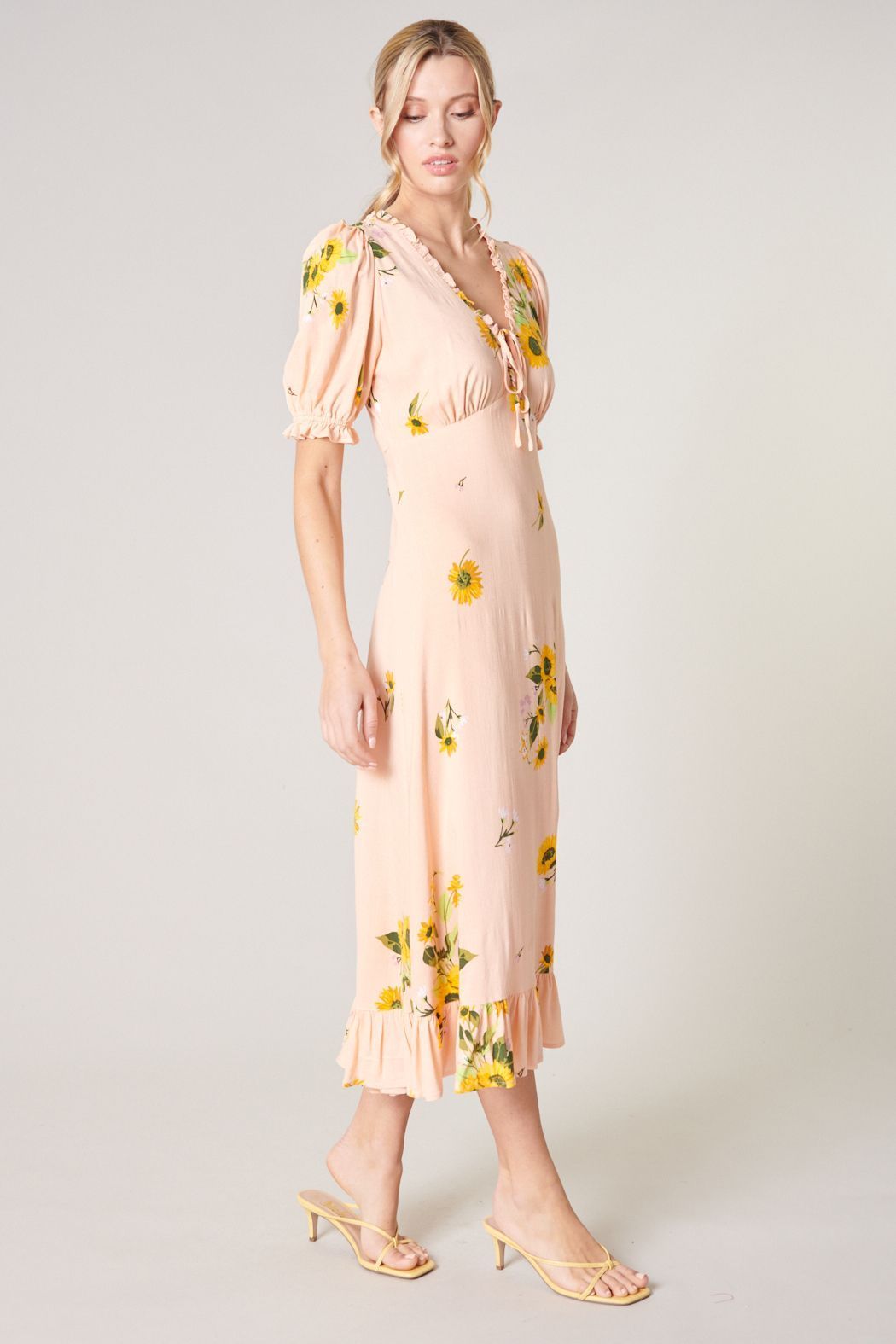 Side view of soft yellow floral midi dress with puff sleeves and feminine silhouette