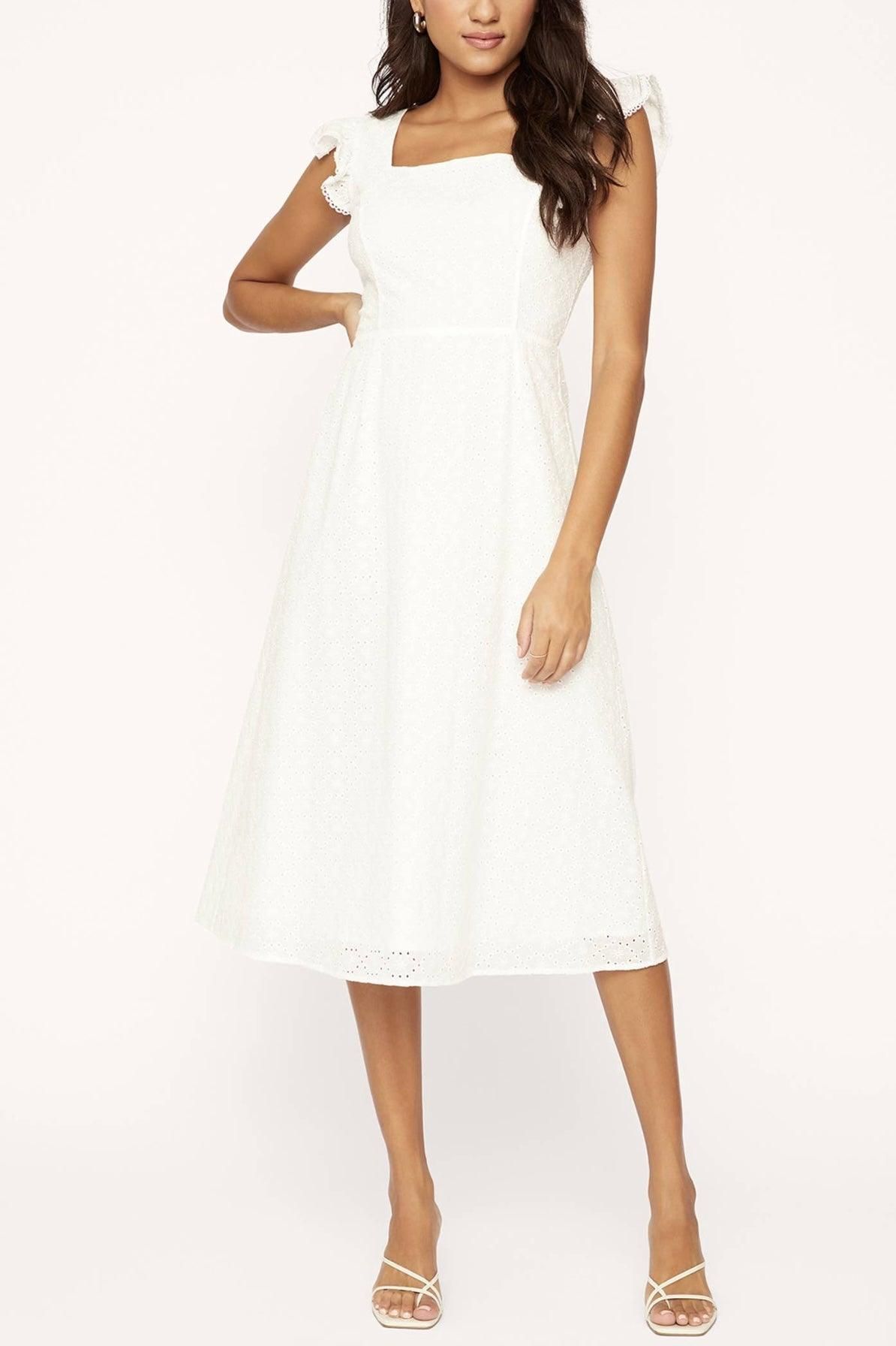Closer front view of the Hoku Hawaii white midi dress showing tonal eyelet embroidery, ruffled straps and a defined waist.