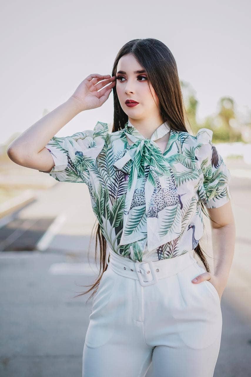 Front view of the Like the Moon tropical print blouse, showing its bow neckline and short puff sleeves.